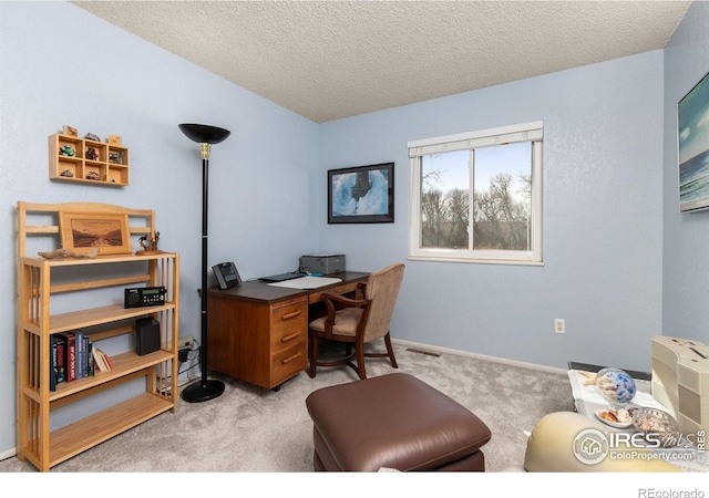 carpeted office space with a textured ceiling