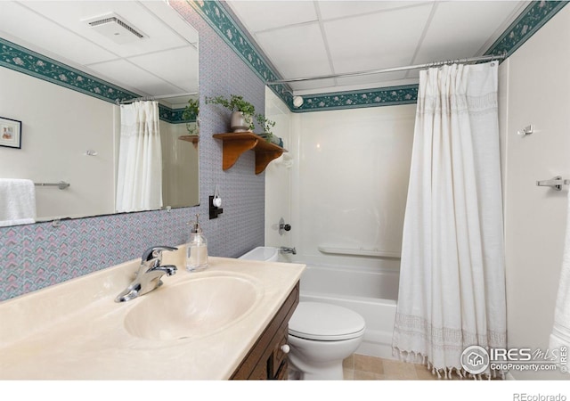 full bathroom featuring shower / tub combo with curtain, vanity, toilet, and a drop ceiling