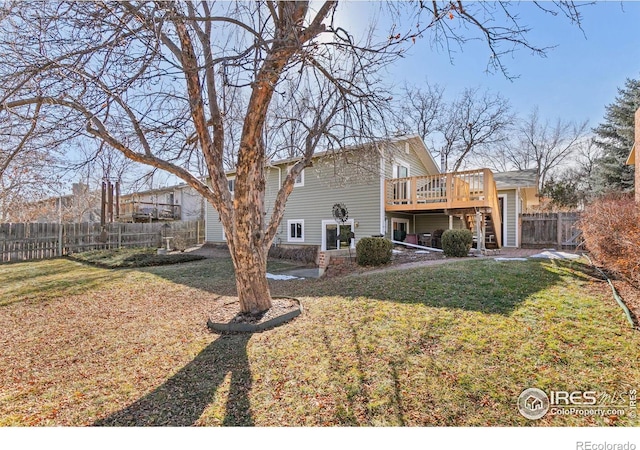 rear view of house featuring a deck and a lawn