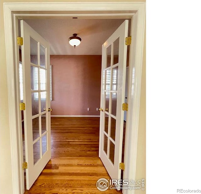 hall featuring hardwood / wood-style floors and french doors