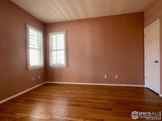 spare room with dark hardwood / wood-style floors