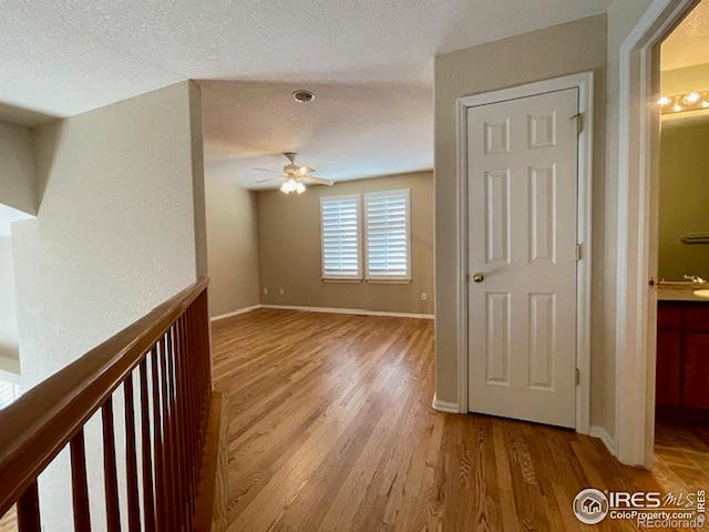 interior space with ceiling fan, light hardwood / wood-style floors, and a textured ceiling