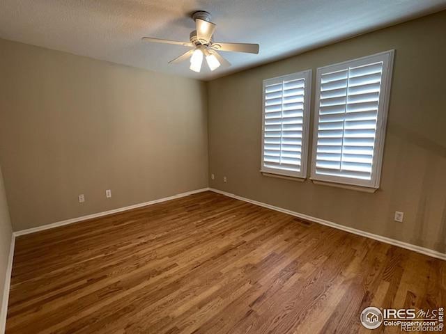 spare room featuring hardwood / wood-style floors and ceiling fan