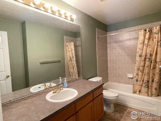 full bathroom with tile patterned floors, toilet, a textured ceiling, vanity, and shower / bath combo with shower curtain