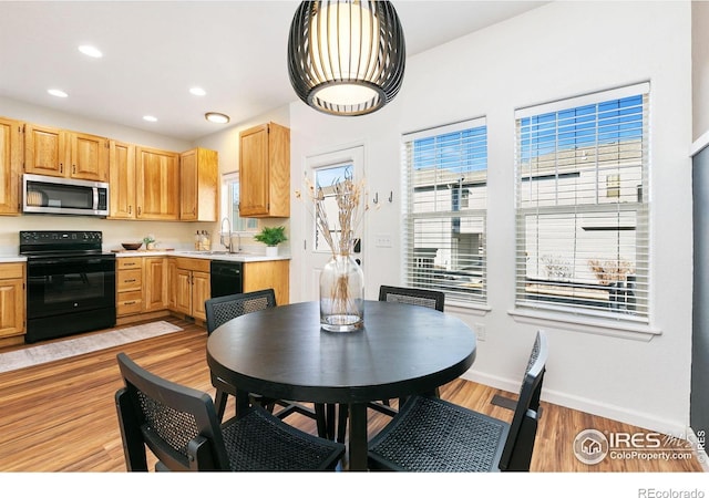 kitchen featuring a wealth of natural light, light wood-type flooring, and black appliances