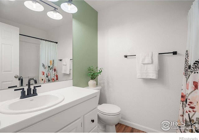 bathroom featuring wood-type flooring, toilet, and vanity