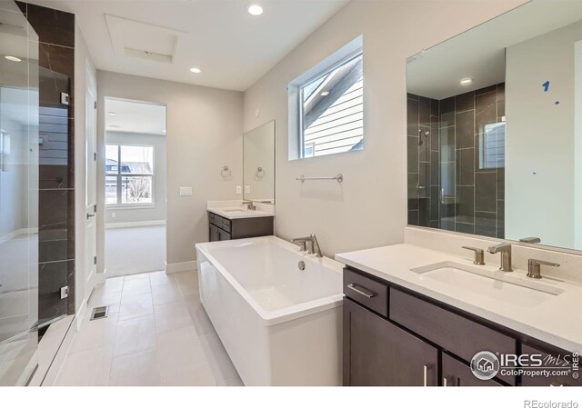 bathroom with recessed lighting, a soaking tub, a sink, and a shower stall