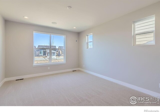 empty room with recessed lighting, visible vents, baseboards, and light colored carpet