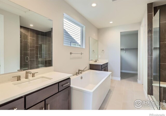 full bath featuring a freestanding bath, a stall shower, a sink, and recessed lighting