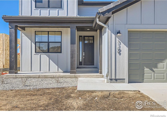 entrance to property with board and batten siding and a garage