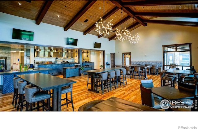 dining room featuring wood ceiling, high vaulted ceiling, a chandelier, light hardwood / wood-style floors, and beamed ceiling