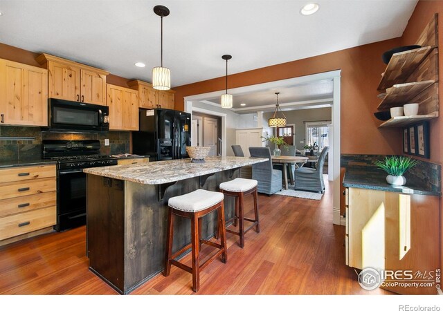1005 Laporte Ave, Fort Collins, CO 80521 - kitchen featuring dark hardwood / wood-style flooring, decorative light fixtures, black appliances, and a kitchen island
