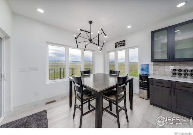 dining area with a chandelier and light hardwood / wood-style flooring