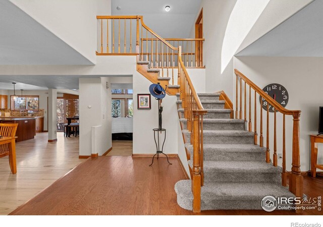 stairway featuring hardwood / wood-style floors and a high ceiling