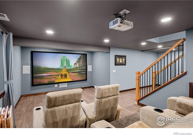 cinema room with light hardwood / wood-style floors and radiator