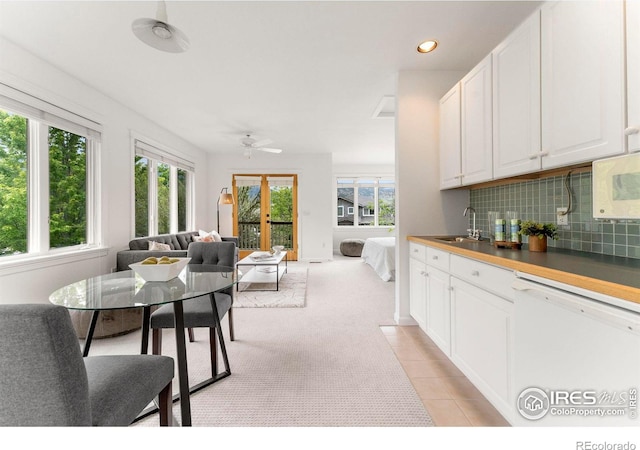 kitchen featuring sink, white cabinetry, tasteful backsplash, plenty of natural light, and white appliances