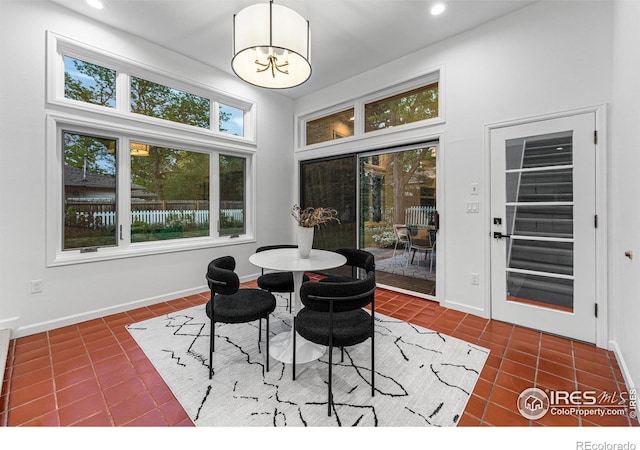 tiled dining room with an inviting chandelier