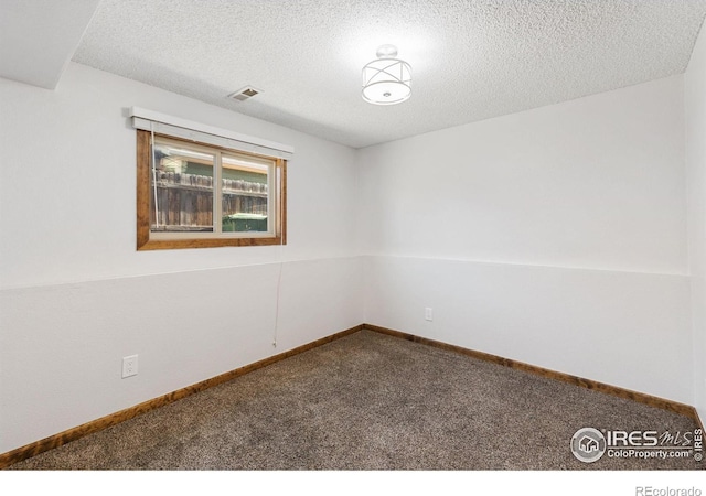 spare room with carpet floors and a textured ceiling