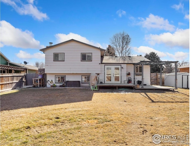 rear view of property featuring french doors, a wooden deck, a yard, and a pergola