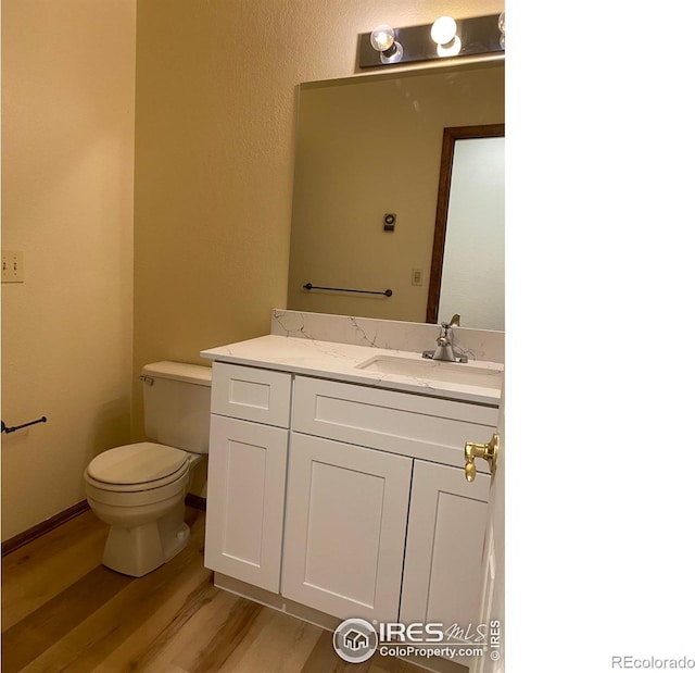 bathroom with vanity, hardwood / wood-style floors, and toilet