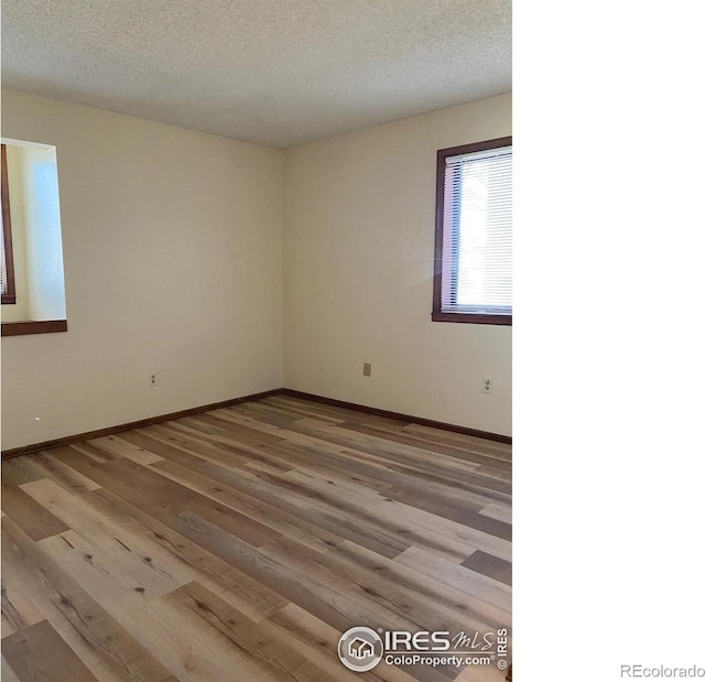 empty room featuring light hardwood / wood-style flooring and a textured ceiling