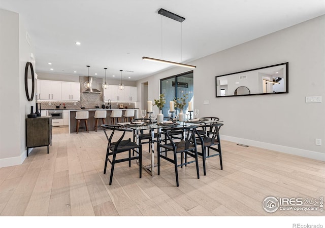 dining space featuring sink and light hardwood / wood-style flooring