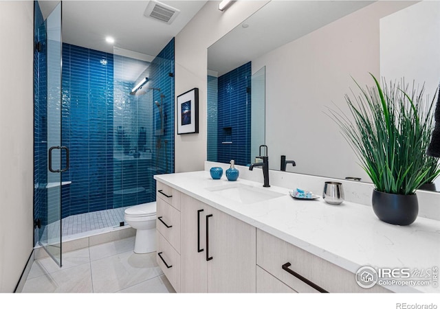 bathroom with vanity, walk in shower, tile patterned floors, and toilet