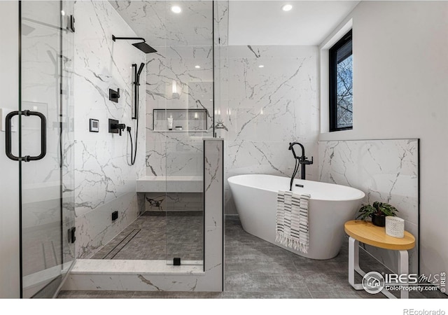 bathroom featuring separate shower and tub and tile walls