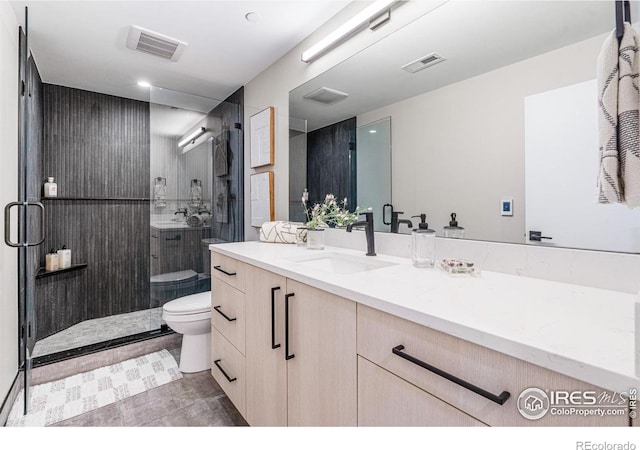 bathroom featuring vanity, a shower with shower door, and toilet