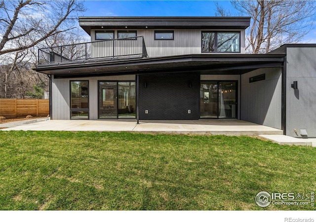 back of property featuring a balcony, a yard, and a patio area