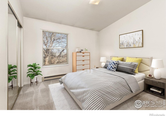 carpeted bedroom featuring a baseboard heating unit, vaulted ceiling, and a closet