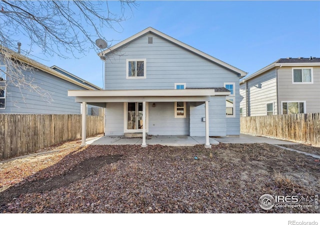 back of property featuring a fenced backyard and a patio