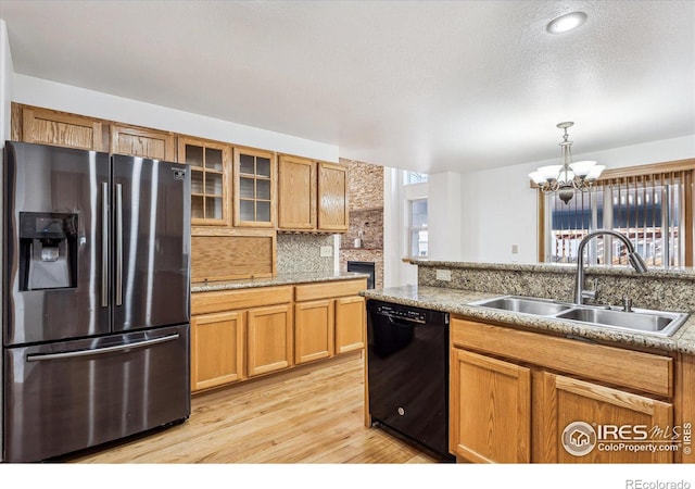 kitchen with dishwasher, stainless steel fridge with ice dispenser, light wood-style flooring, glass insert cabinets, and a sink