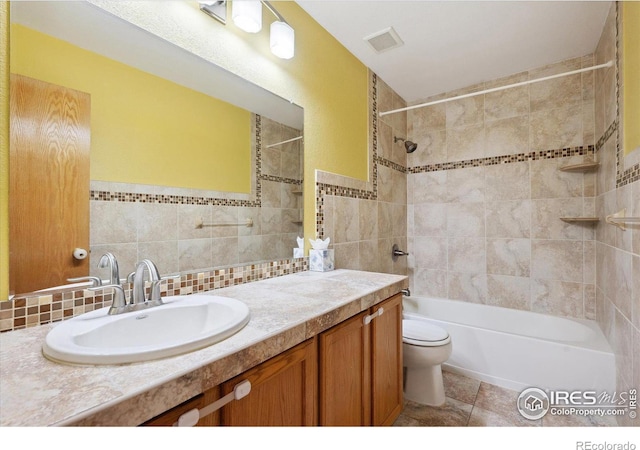 full bathroom featuring tile walls, shower / bath combination, visible vents, toilet, and vanity