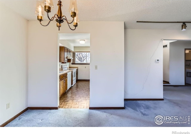 kitchen with white range with electric cooktop, light colored carpet, a textured ceiling, and a notable chandelier