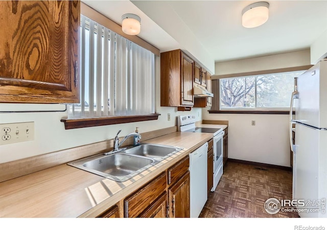 kitchen featuring dark parquet flooring, sink, and white appliances