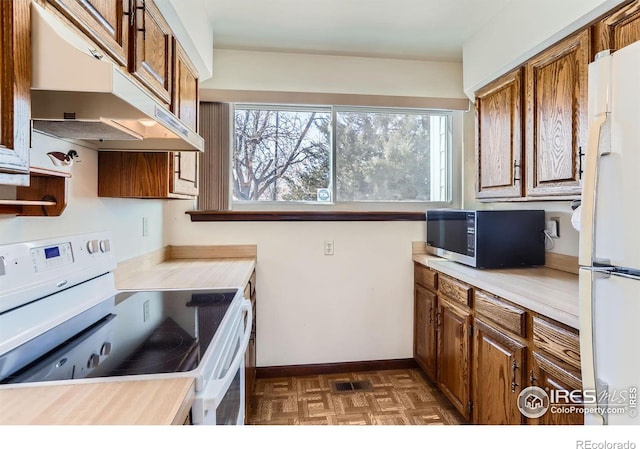 kitchen with dark parquet flooring and white appliances