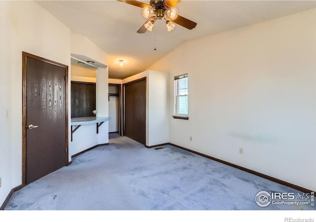 unfurnished bedroom with light carpet, lofted ceiling, and ceiling fan