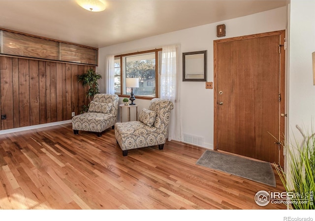 interior space with wooden walls and light wood-type flooring