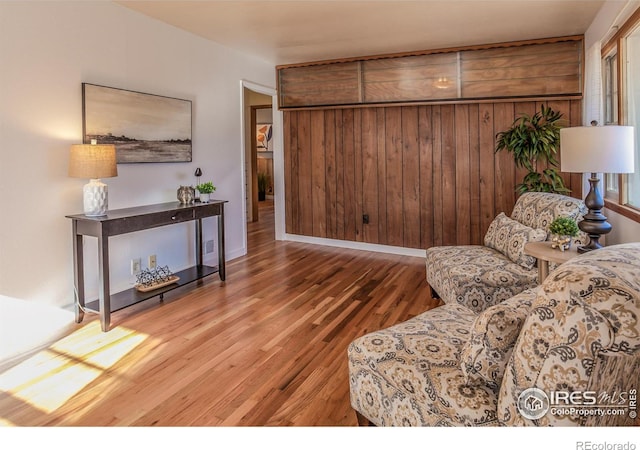 living room with hardwood / wood-style flooring and wooden walls