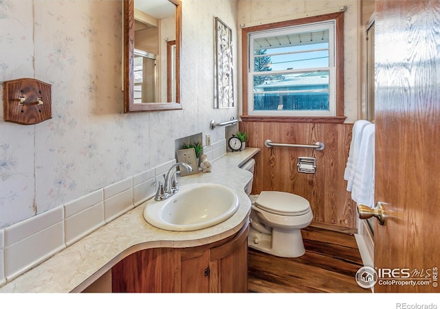 bathroom featuring vanity, wood-type flooring, walk in shower, and toilet