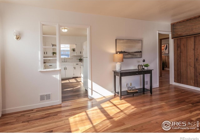 hall with wood-type flooring and sink