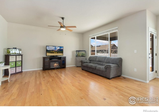 living room featuring ceiling fan and light hardwood / wood-style floors