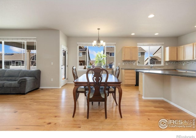 dining area with sink, light hardwood / wood-style flooring, and a chandelier