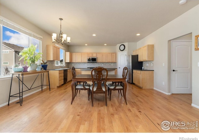 dining space featuring an inviting chandelier and light wood-type flooring