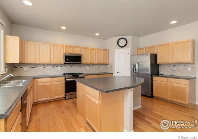 kitchen with sink, appliances with stainless steel finishes, a center island, light hardwood / wood-style floors, and light brown cabinetry