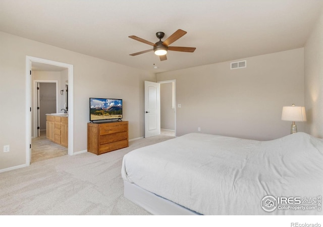 carpeted bedroom featuring ceiling fan and ensuite bath