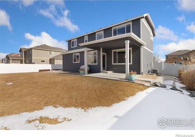 snow covered house featuring central AC and a patio area