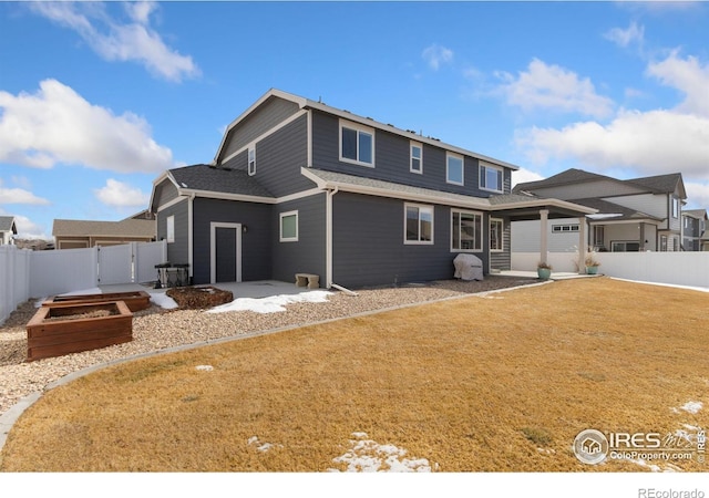 rear view of house featuring a garage and a yard