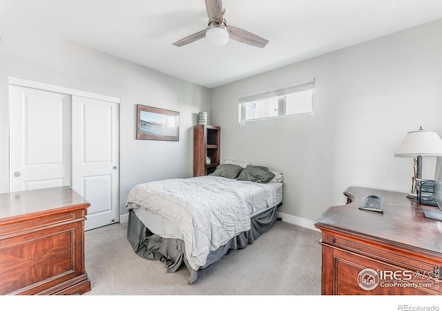 bedroom featuring light colored carpet, ceiling fan, and a closet